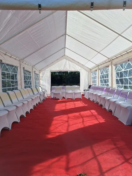 Red-carpet aisle with rows of white chairs