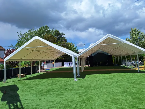 Two open-sided marquees on a lawn