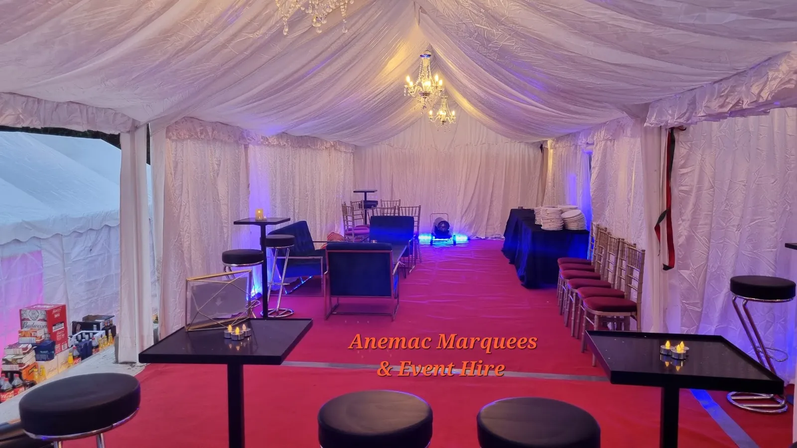Lined marquee with red carpet, poseur tables and stools