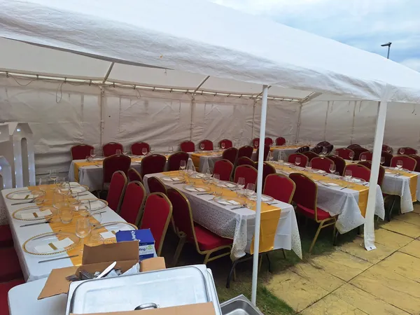 Open-sided marquee with dining tables and banquet seating