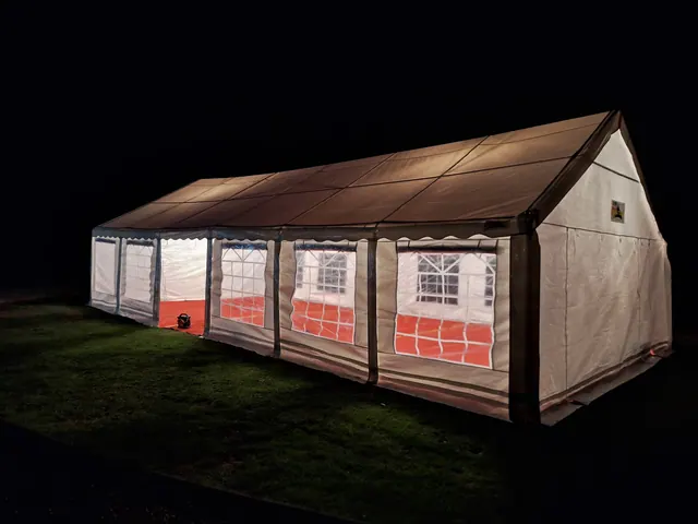 A window-sided marquee illuminated after dark on a lawn