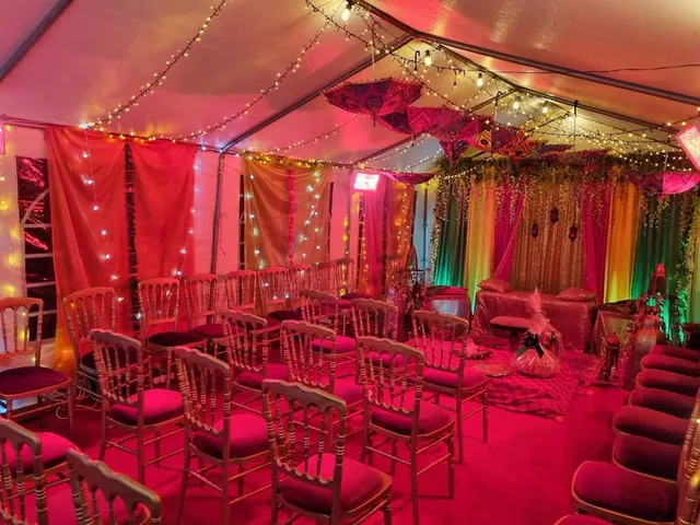 A colourful marquee interior with gold seating and warm string lights