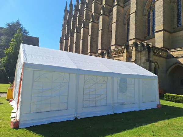 White framed marquee beside a stone building